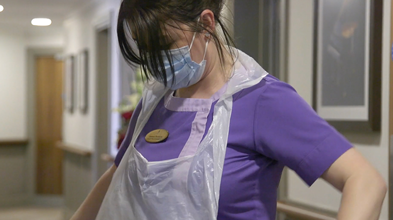 carer putting on an apron