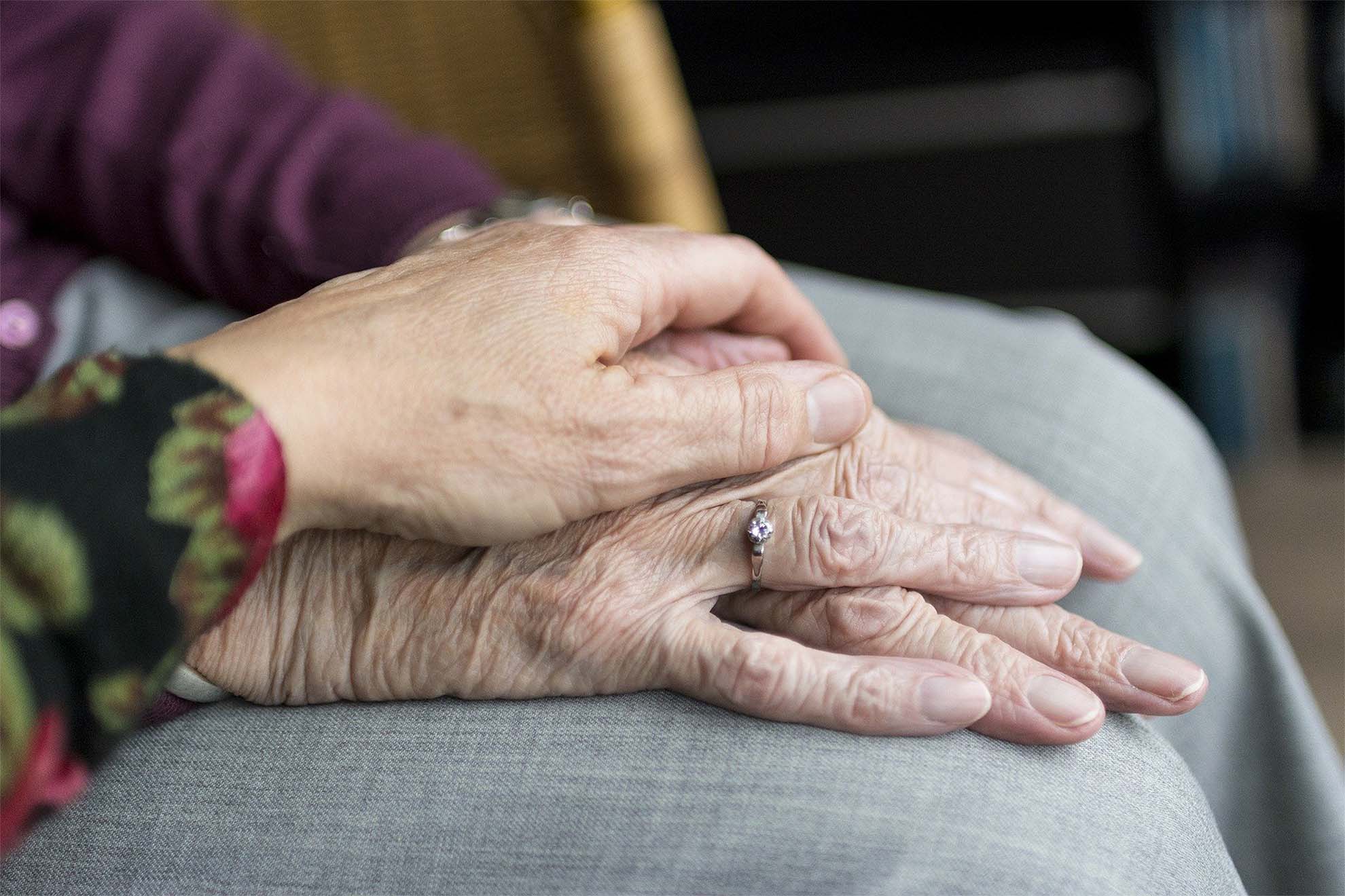 older people holding hands