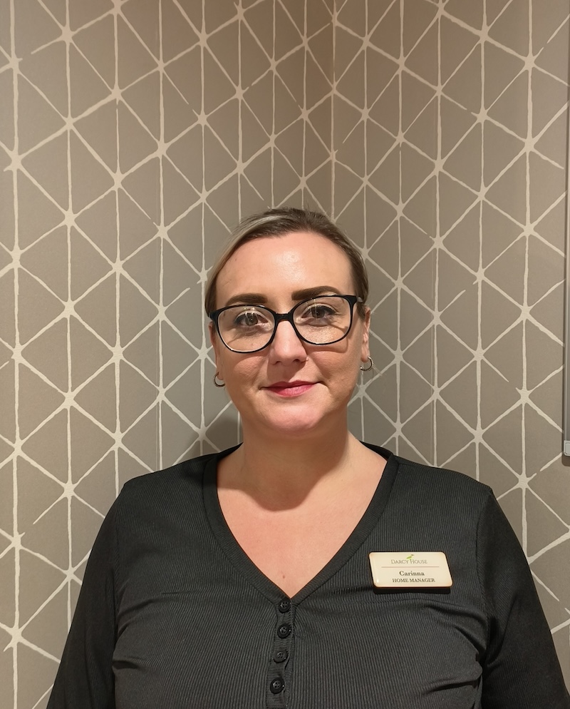 female with her hair tied back having a headshot taken for the team page