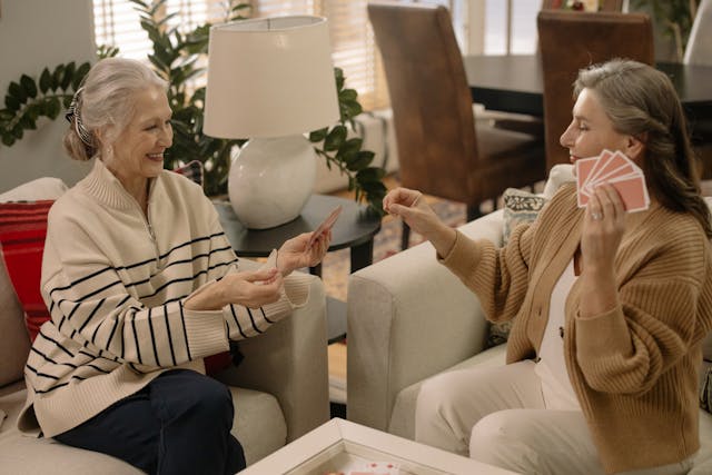 two older women sat on the sofa talking and smiling
