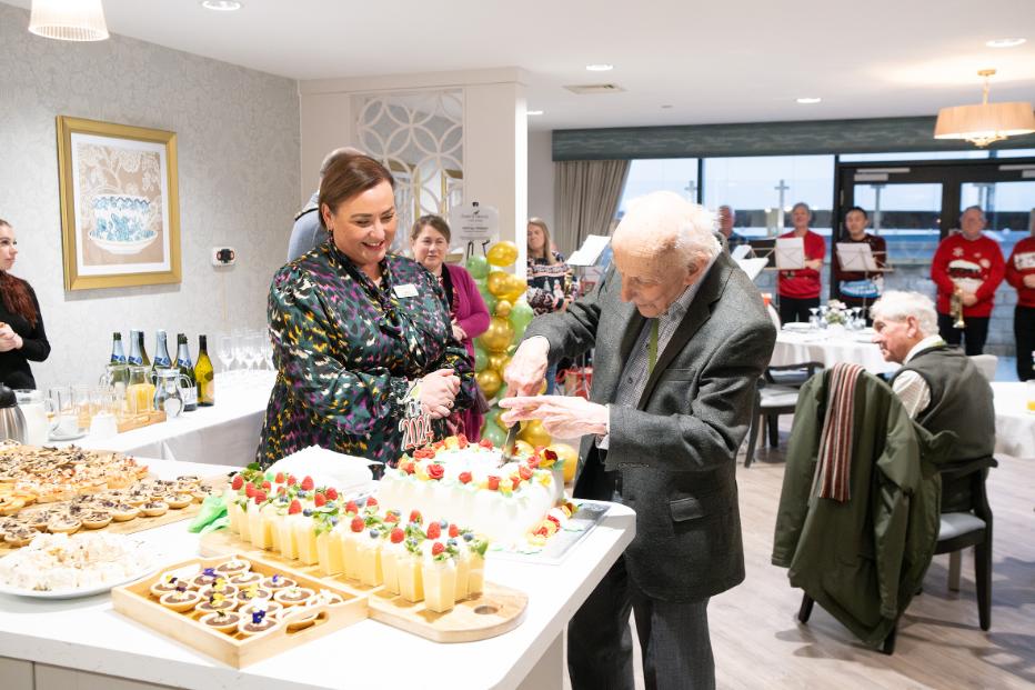 Darcy House Grand Opening - Resident cutting cake