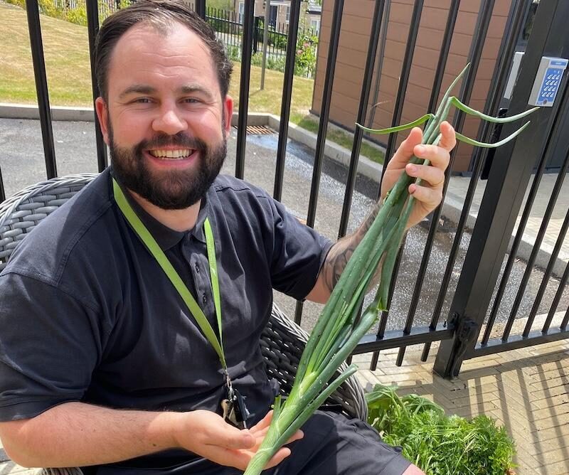 our gardener holding home grown veg in his hand