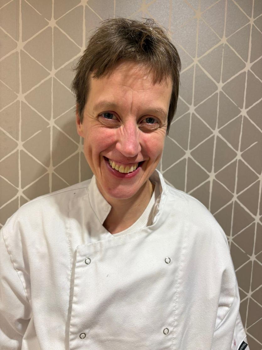 woman in chef uniform smiling at camera