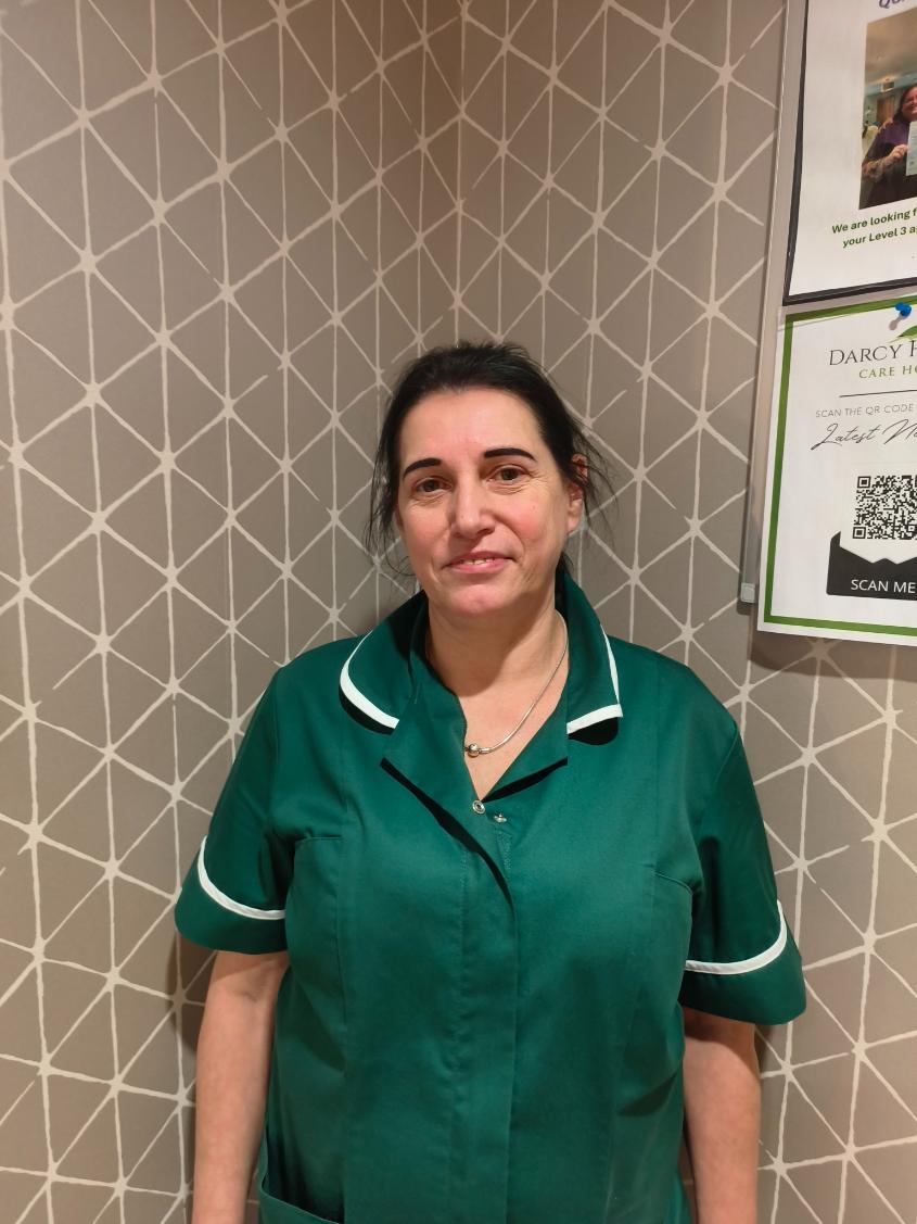 woman in housekeeping uniform looking at camera for staff photo