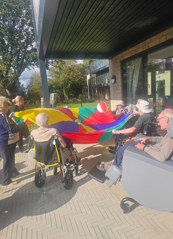 residents outside lifting a parachute